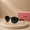 MIU MIU Rimless Oval Geometric Sunglasses – Black Lenses with Gold Bow Logo Temples